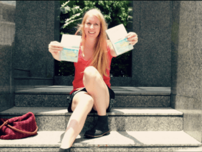 girl holding up two passports