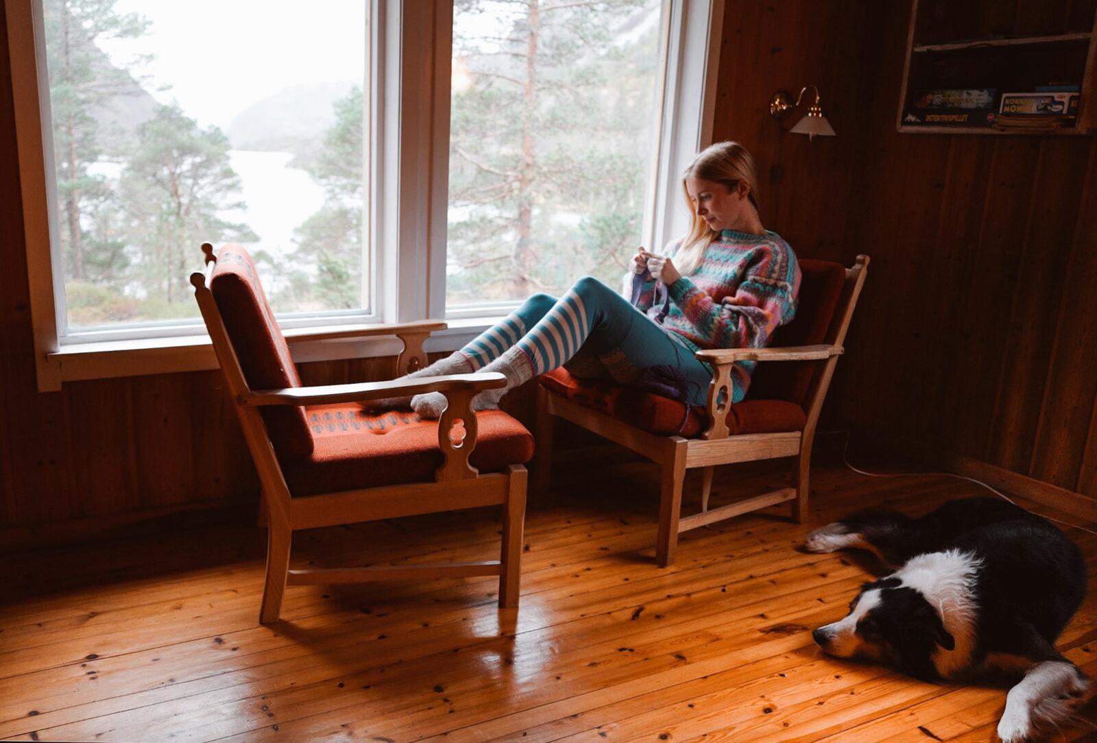 knitting a sweater in front of a large window
