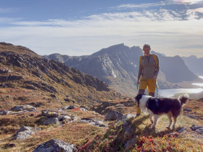 Woman and dog on mountain in Lofoten