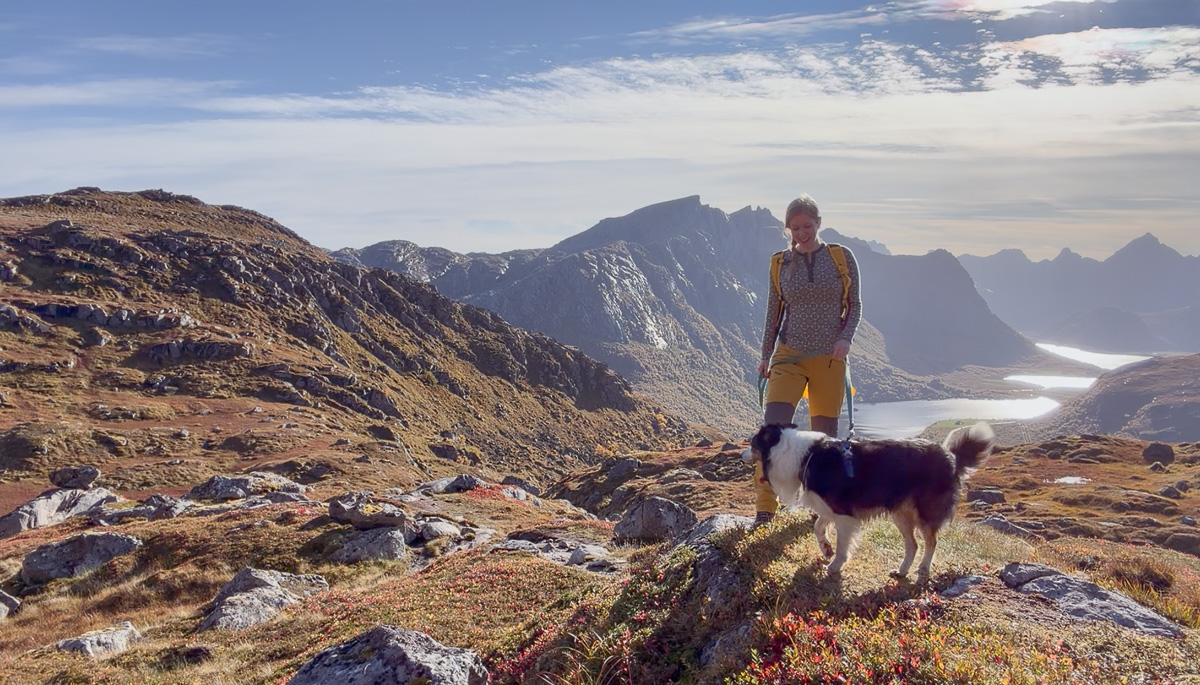 Woman and dog on mountain in Lofoten